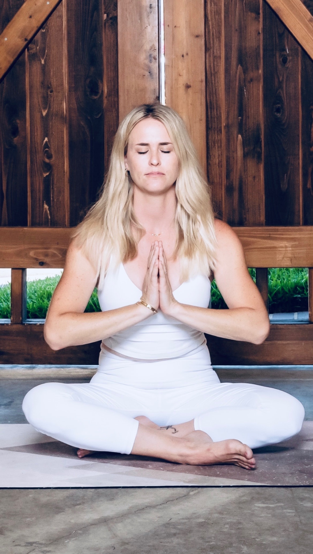 Kristin Macshane sitting cross-legged in a calm meditative yoga pose